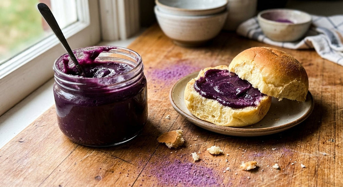 Glass jar of homemade ube halaya purple yam jam with a slice of bread spread with halaya on a wooden table